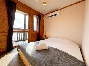 a bedroom with a bed and a large window at Cloud9 Toya in Lake Toya