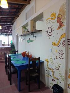 a dining room with a blue table and chairs at Hostel IndiaJara in Itacaré