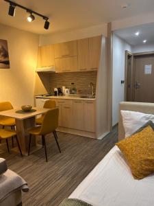 a room with a bed and a table and a kitchen at Tri-M Konaci in Kopaonik