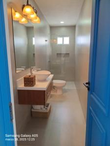 a bathroom with a sink and a toilet and a mirror at Villa Karol in Rivas