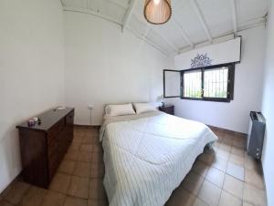 Barrio El RetazoCasa las margaritas的一间卧室，里面有一张床、一张桌子和一扇窗户