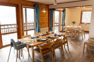 a dining room with a table and chairs and windows at Cloud9 Toya in Lake Toya