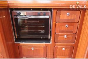 an oven in a kitchen with wooden cabinets at Jedrilica PERUN in Kravlja