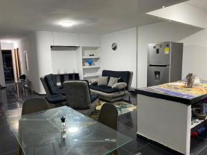 a living room with a table and a kitchen at Apartamento Brisa Marina cómodo y accesible in Santa Marta