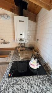 a kitchen counter with a stove with a cake on it at Departamento a las afueras para 4 in San Martín de los Andes