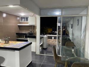 a kitchen with a counter and a table with chairs at Apartamento Brisa Marina cómodo y accesible in Santa Marta