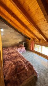 a bedroom with a large bed in a attic at Departamento a las afueras para 4 in San Martín de los Andes