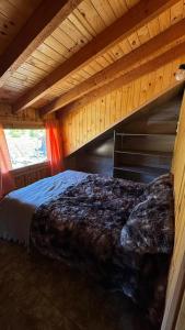a large bed in a room with a wooden ceiling at Departamento a las afueras para 4 in San Martín de los Andes