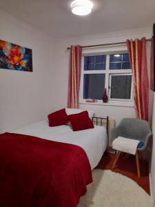 A Four Bedroom House في Tettenhall: غرفة نوم بها سرير ونافذة وكرسي