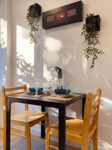 een eettafel met 2 stoelen en een zwarte tafel bij Bohemian Rust in Chişinău