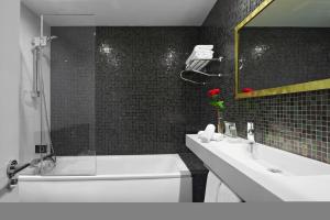 a bathroom with a sink and a bathtub at Caesar Hotel in London