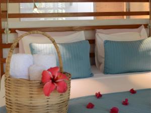 a basket of towels and a red flower on a bed at Praiagogi Boutique Pousada in Maragogi +28 photos