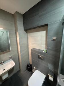 a bathroom with a white toilet and a sink at Ameri Plaza Lilu Home apartment in Tbilisi City +9 photos