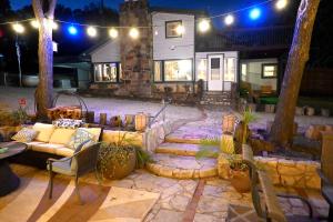 a patio with a couch and some plants and lights at Hotel Oasis with Outdoor Kitchen in Fall River