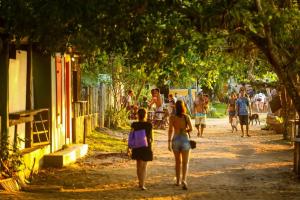 a group of people walking down a street at Casa da Vila in Caraíva