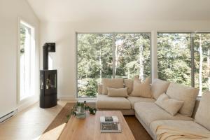 a living room with a couch and large windows at Maison Solus - Mont Tremblant in Lac-Superieur +40 photos