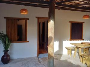 a dining room with a table and a wooden pole at Casa da Vila in Caraíva +32 photos