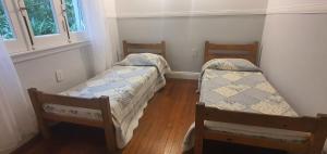 two twin beds in a room with wooden floors at Hotel Cuba in Buenos Aires
