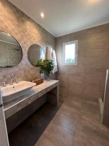 een badkamer met een wastafel en 2 spiegels bij Atardecer de San Benito in La Estafeta