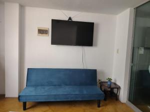 a blue couch in a room with a flat screen tv at Kaihalulu Beach Room - Punta Hermosa in Punta Hermosa