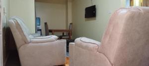 zwei leere Stühle in einem Zimmer mit einem Fernseher in der Unterkunft Rosslyn suites in Juja