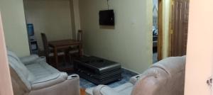 a living room with two couches and a tv at Rosslyn suites in Juja