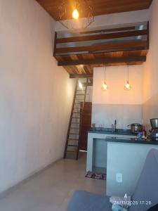 a kitchen with a counter and a staircase in a room at Loftshorizontedesalvina in Búzios