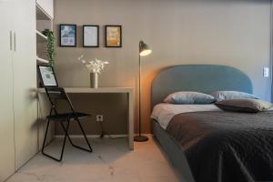 a bedroom with a bed and a desk and a lamp at Locarno Center - Free Parking, Netflix and WiFi in Locarno