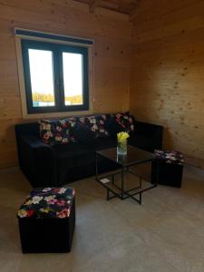 a living room with a black couch and a table at Test Property in Bosanska Gradiška