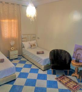 una camera con 2 letti singoli e una sedia di Marrakech airport a Marrakech