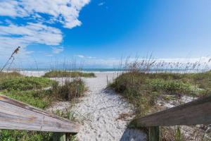een pad naar het strand met een houten hek bij 400 South - Unit F in Cocoa Beach
