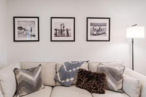 een witte bank in een woonkamer met foto's aan de muur bij 400 South - Unit F in Cocoa Beach