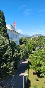 a road with trees in front of a white building at Zero Distance Studio in Podgorica