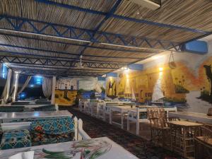 ein Restaurant mit Tischen und Stühlen und einem Wandbild in der Unterkunft Endo Mando in Shellal