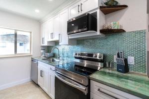 a kitchen with a sink and a stove top oven at 400 South - Unit G in Cocoa Beach +30 photos