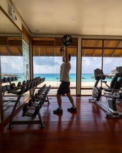 FushifaruFushifaru Maldives with 50 percent off on sea plane roundtrip 04 nights & above的健身房里一个男人正在举重