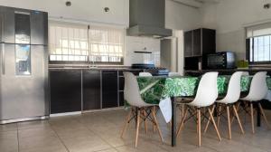 a kitchen with a table with white chairs in it at summer house in La Porteña