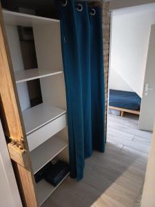 a closet with blue curtains in a room with a bed at Beau studio à 2mn de la mer et avec jardin in Bray-Dunes