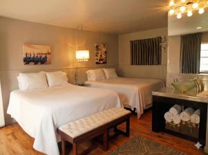 una camera d'albergo con due letti e un tavolo di The Crest Motel a Sterling