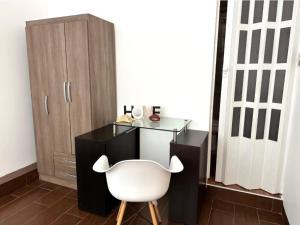 a desk and a white chair in a room at Hospedaje en Pimentel, playa in Pimentel