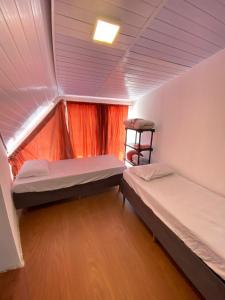 a small room with two beds and a ladder at Quarto Duplo Casal Jd Botânico in Curitiba