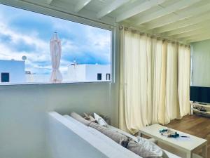 a living room with a large window and a couch at Alojamiento Vacacional con balcón La Vela in Puerto Calero
