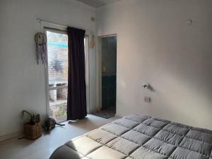 特雷利乌Espacios únicos en una amplia casa a metros de una laguna natural的一间卧室，里面有一张床和一扇大窗户。