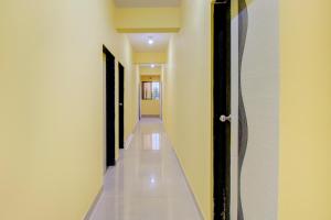 TitwalaHotel O Tare Farms的一条带白色墙壁和黑色门的走廊