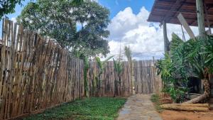 una recinzione di legno accanto a un passaggio pedonale in un cortile di Casa no centro da Serra do Cipó a Santana do Riacho