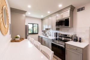 een keuken met witte kasten en witte aanrechtbladen bij 400 South - Unit H in Cocoa Beach