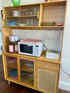 a microwave oven sitting on top of a wooden cabinet at Smithtown Champagne Bed and Bubbles in Smithtown