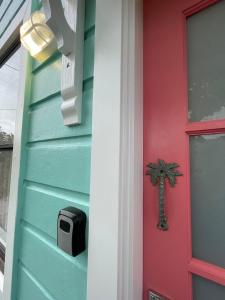 a door to a house with a palm tree on it at Smithtown Champagne Bed and Bubbles in Smithtown