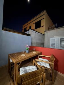 un tavolo di legno e due sedie su un balcone di Jimaguas a Tamaduste