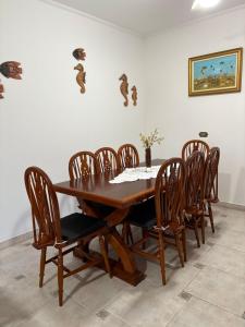 a dining room with a wooden table and chairs at Enseada Malibu perto da praia, lazer e conforto! in Guarujá